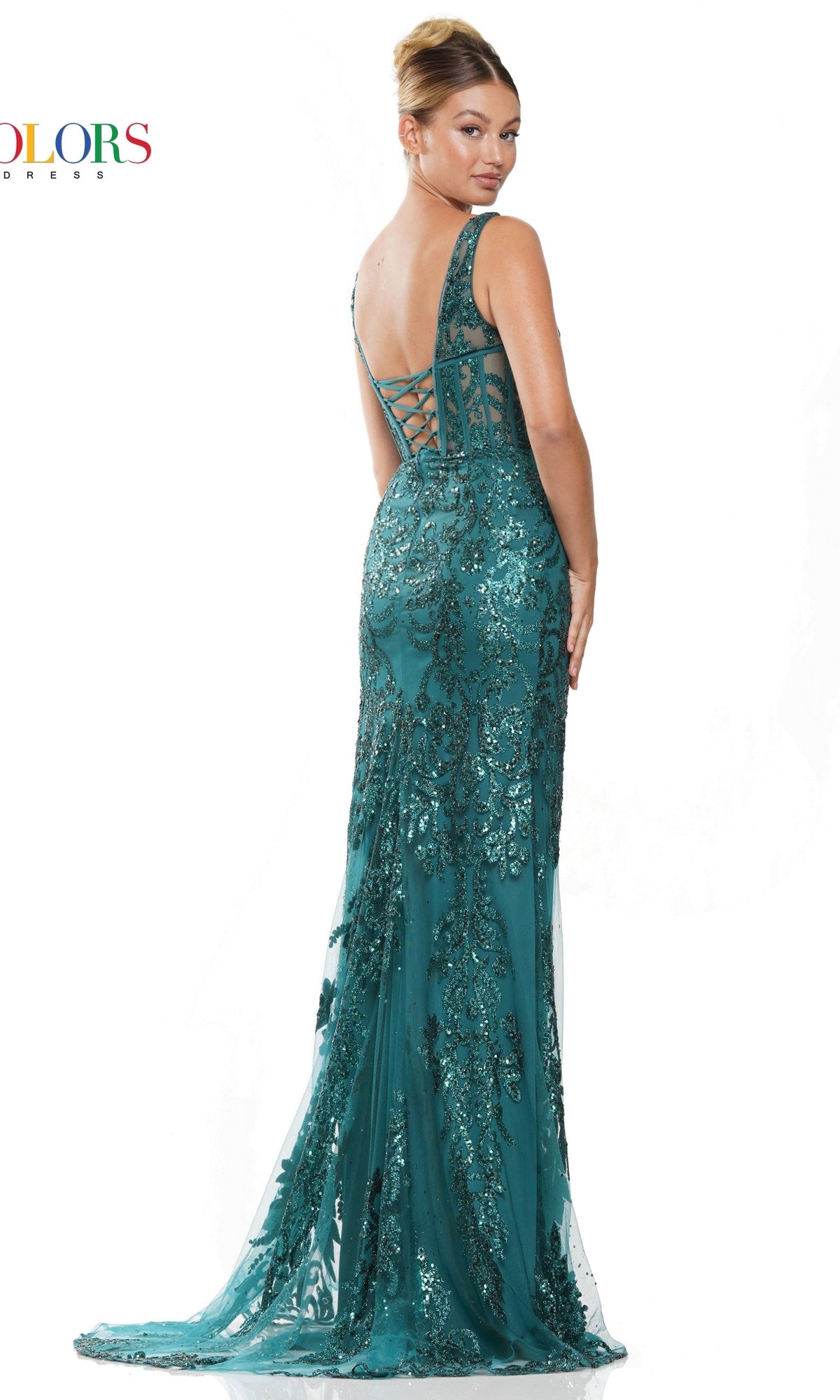 A woman stands against a white background, looking over her shoulder and wearing the Sheer-Waist Glitter-Print Long Prom Dress 2990—an elegant, floor-length formal gown with shimmering details and a lace-up back.